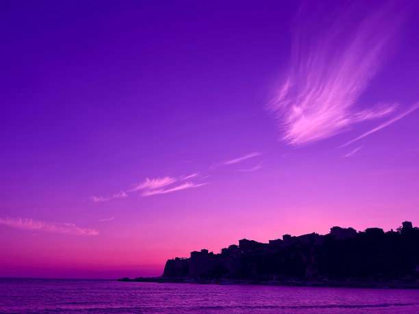 明亮的日落在老城和海水在晚上。图片下载