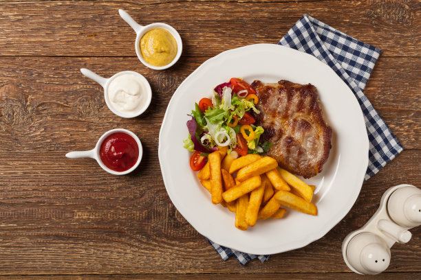 烤猪颈肉配薯条和沙拉。图片下载