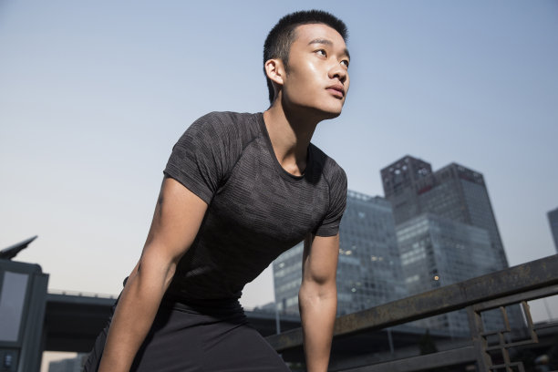 年轻的东亚男子在清晨的城市街道上进行体育训练-库存照片图片下载