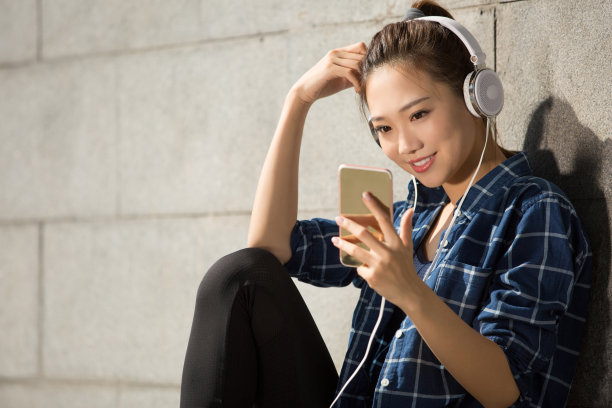 年轻女子使用智能手机后白天的城市街道滑板练习-股票照片图片下载