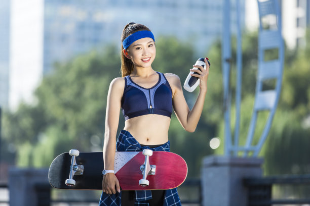 年轻的东亚妇女肖像后城市街头滑板-股票的照片图片下载