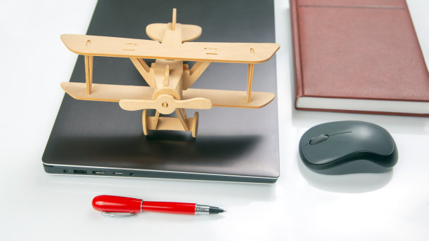笔记本电脑背景上的木制飞机模型。业务发展和成功。梦想在你最喜欢的行业飞行。图片下载