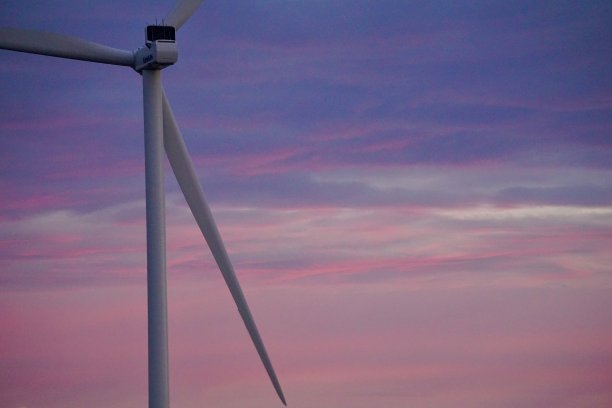 斯堪的纳维亚半岛日落时的风力发电场。丹麦海边的风车。美丽的火红夕阳和风车。海滩、沙滩和海洋上的风电场。图片下载