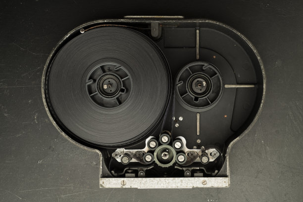 胶片照相机的卡带中的胶片。卡式磁带驱动机构中的负片。电影制作展示商业技术概念图片下载