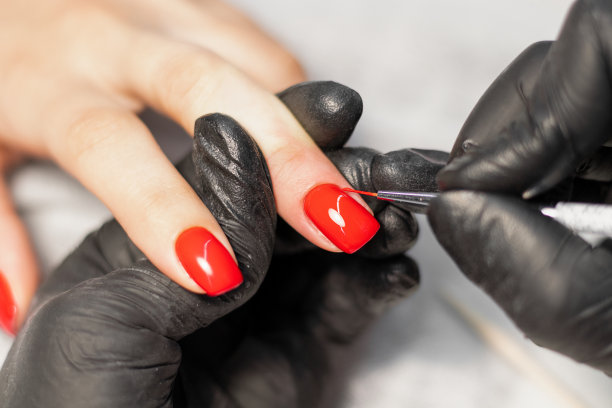 特写照片的一个美丽的女性的手与红色的指甲。指甲上涂指甲油。红色的指甲图片下载