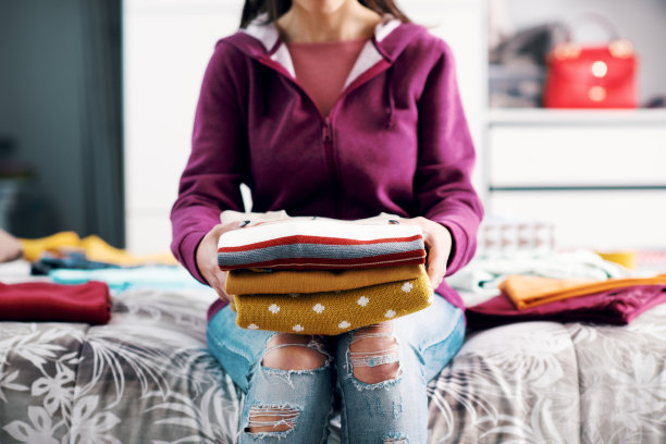 拿着一堆衣服的女人图片下载