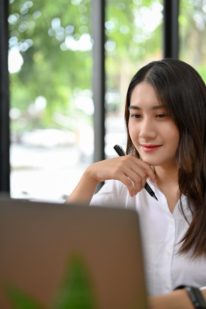 迷人的亚洲女商人或女大学生使用笔记本电脑。图片下载