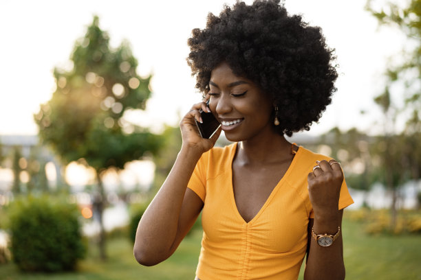 快乐的非洲裔美国年轻女性在城市里用手机聊天图片下载