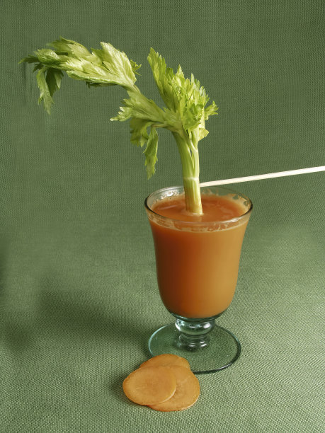 血腥玛丽鸡尾酒装在隔热玻璃里，绿色底座上有胡萝卜片和芹菜杆图片下载