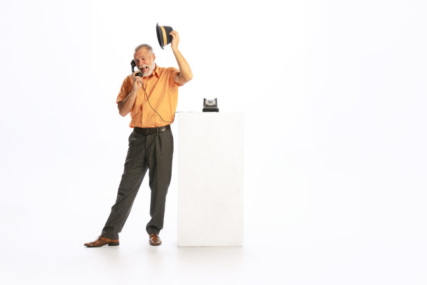 感性的肖像高级男子在复古风格的衣服，复古装备使用手机孤立在白色背景。文化理念、艺术、时尚风格、广告图片下载