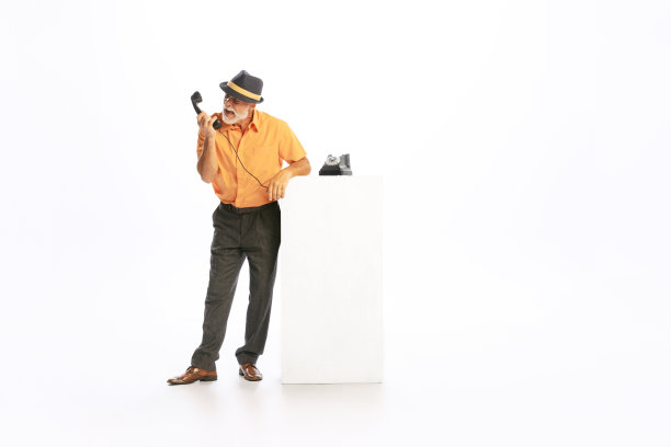 感性的肖像高级男子在复古风格的衣服，复古装备使用手机孤立在白色背景。文化理念、艺术、时尚风格、广告图片下载