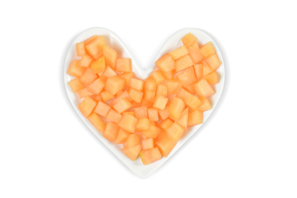 新鲜切块的哈密瓜在心脏盘子与修剪路径-心脏健康的概念图片下载