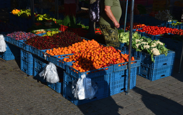 高物价和通货膨胀迫使人们从市场上直接从初级生产者那里购买水果、蔬菜和烘焙食品。塑料盒子里的圆面包。杏子和面包房图片下载