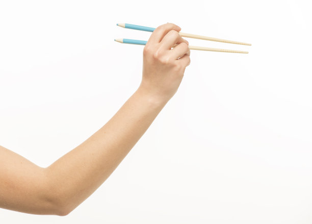 手持筷子在白色背景上孤立图片下载