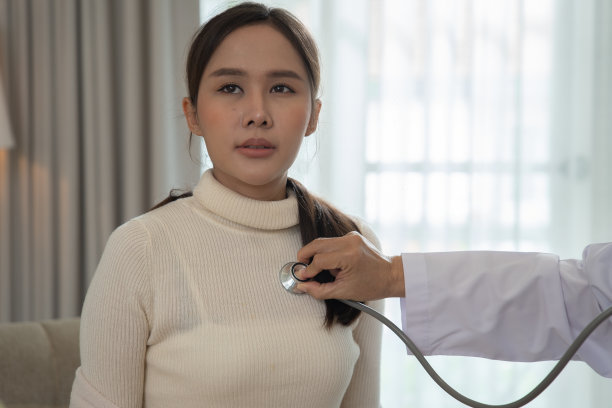 在家不健康的妇女在毛毯下生病咳嗽并咨询医生图片下载