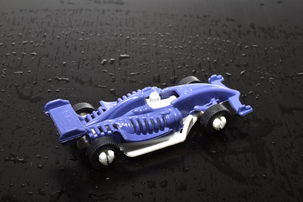 黑色背景上立着一辆蓝色的赛车。图片下载