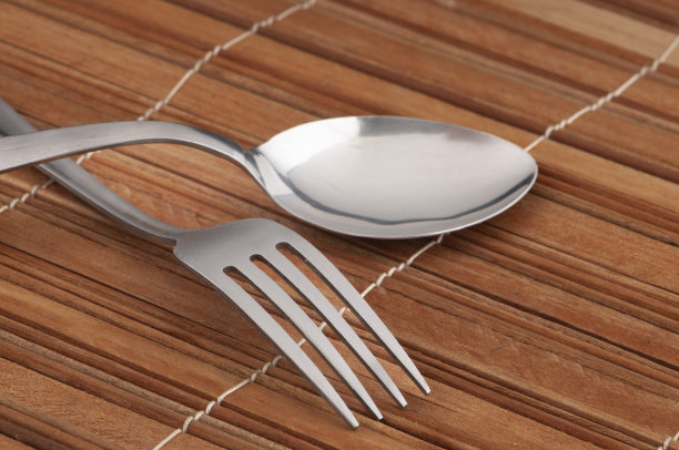 叉子和勺子放在木制底座上图片下载