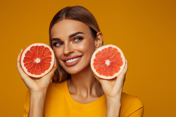 手持红色葡萄柚的女孩肖像图片下载