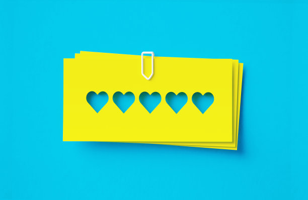 黄色黏贴笔记与剪纸心形坐在蓝色背景图片下载