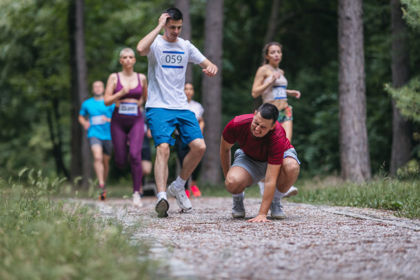 一群运动员在马拉松比赛中帮助受伤的男子图片下载