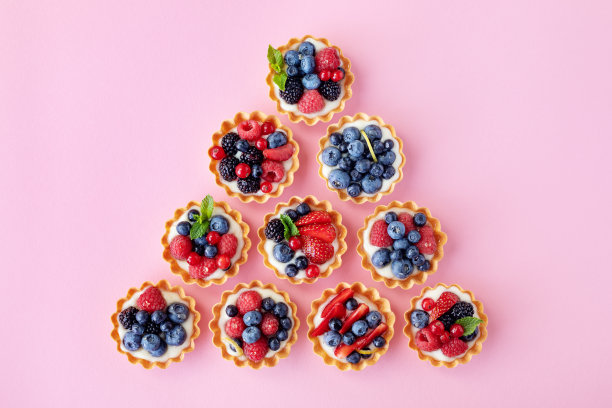 一套不同的馅饼或蛋糕与奶油奶酪，蜂蜜和夏季浆果在粉红色。糕点甜点从上面。平的。图片下载