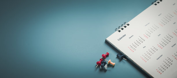 在日历上绣上红色大头针活动策划日历，以时钟设定时间表组织日程，策划商务会议或旅行计划的概念。图片下载