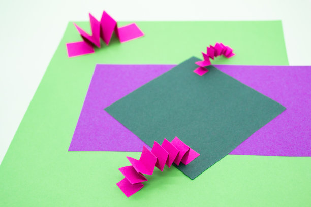 抽象背景在绿色，粉色和紫色的3D纸元素，锯齿图案。作为产品广告的背景、文案空间图片下载