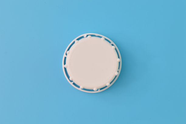 在蓝色背景上孤立的白色瓶盖的近景图片下载