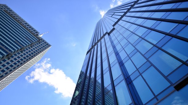 蓝色天空下的现代玻璃立面。商业区一栋建筑的底图。图片下载