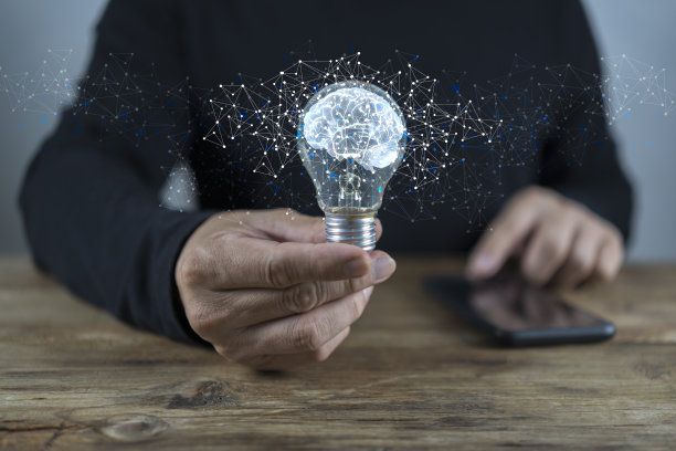 商人手里有个脑子的灯泡。经营理念的概念。图片下载