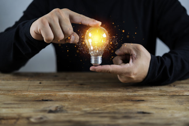 男人拿着灯泡，新思想的想法用创新的技术和创造力。创造力的概念图片下载