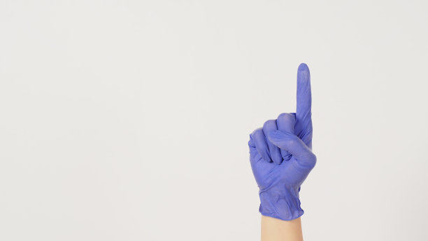 手在白色背景上做一个手指或指向上方的手势。手戴紫色或紫色乳胶手套。图片下载