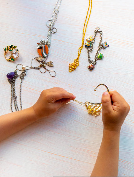 孩子们的手在白色的背景上玩着夏天的小饰品。女性的幸福观。图片下载