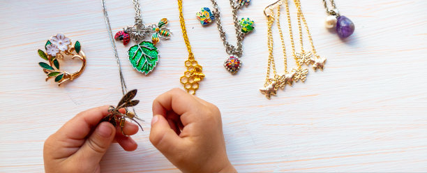 孩子们的手在白色的背景上玩着夏天的小饰品。女性的幸福观。图片下载