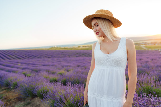迷人的年轻女子穿着夏装站在薰衣草地里图片下载
