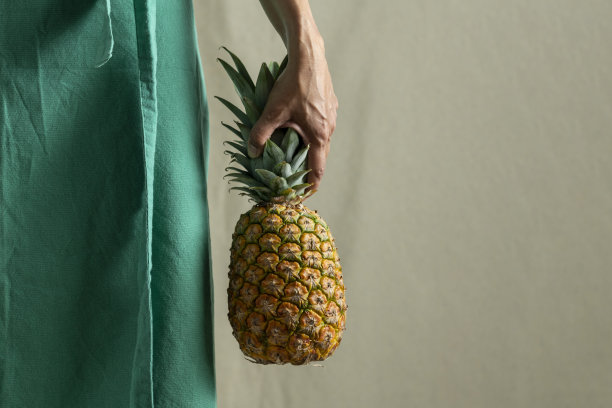 女人拿着菠萝与普通的背景-股票照片图片下载