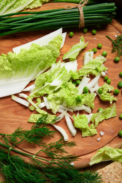 厨房木板上的蔬菜，大葱，莳萝和豌豆，切好的卷心菜放在木头背景上，新鲜健康的食物概念，静物图片下载