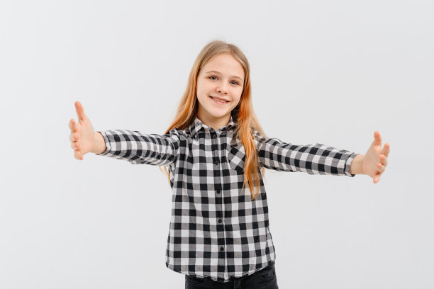 形象快乐微笑的年轻女孩伸出双臂向前，欢迎，拥抱你，站在白色背景的休闲衬衫。图片下载