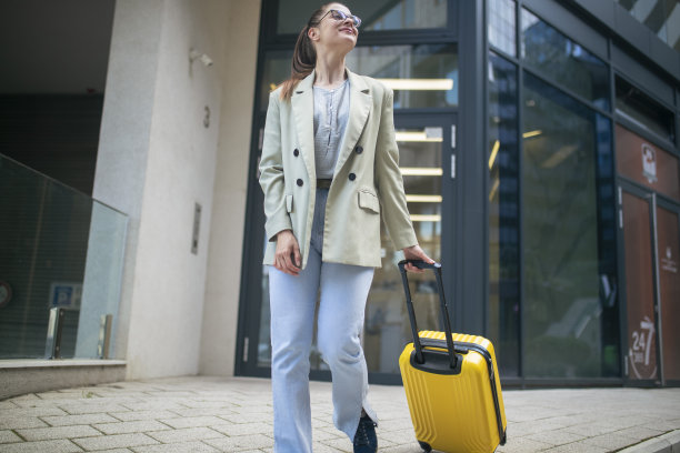 一个带着满意表情的女人刚旅行回来，她在公共汽车站。图片下载