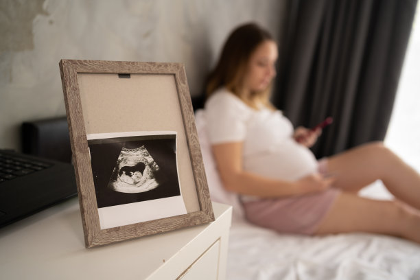 胎儿在框内的超声照片，孕妇在床上的背景，怀孕和超声控制图片下载