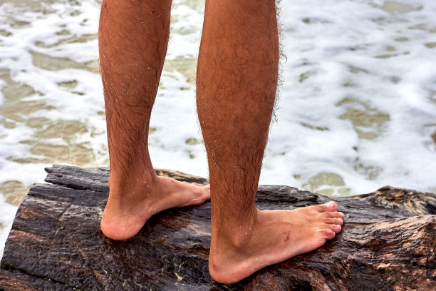 一个人的双腿站在海边的一个障碍物上图片下载