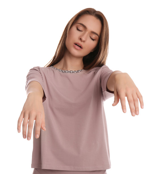 年轻女子穿着睡衣梦游在白色背景图片下载