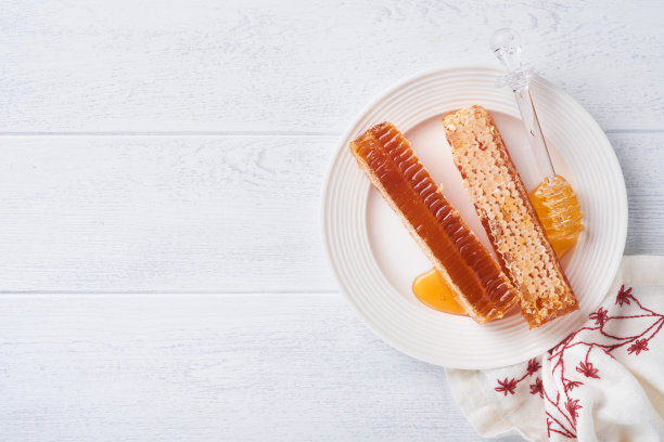 犹太新年。蜂蜜罐，蜂巢，苹果和石榴在白色木制旧质朴的背景表。犹太新年节日贺卡。犹太新年的节日属性。空间的文本图片下载