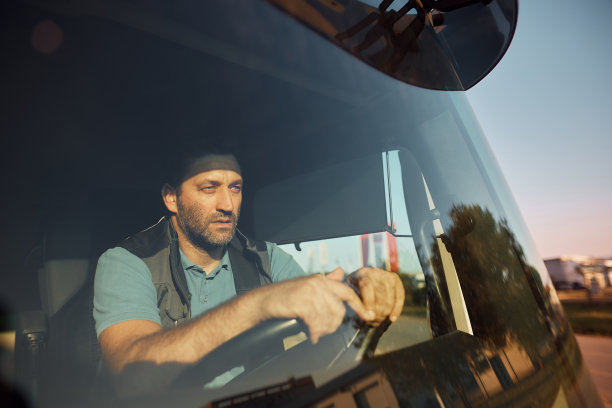 中年职业司机驾驶卡车在路上。图片下载