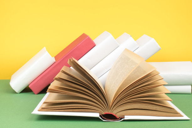 书堆积。打开精装书在木制桌子和绿色背景。回到学校。复制空间的广告文本。图片下载