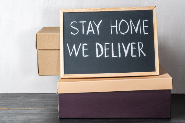 待在家里，我们送货上门，黑色白板上的白色粉笔笔迹图片下载