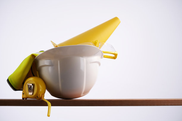 黄色塑料安全帽、眼镜、反光背心和防护手套放在木板上。安全劳动的概念图片下载