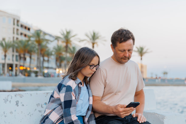 爸爸和女儿在海边看手机图片下载