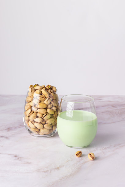 旁边有一杯开心果和一杯开心果牛奶。图片下载