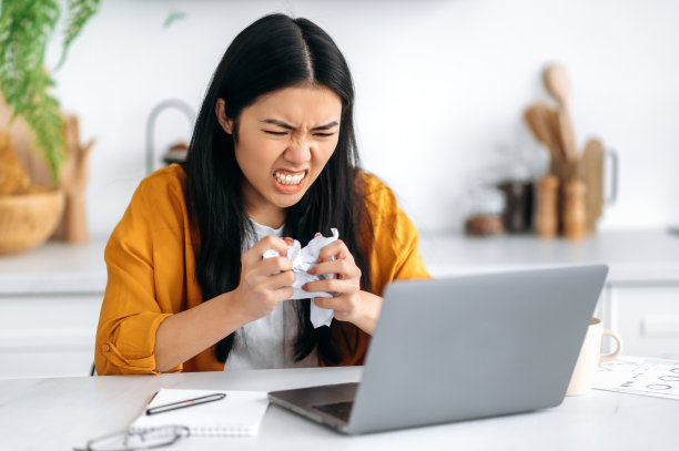 恼怒愤怒的中国女孩，自由职业者或经理，得到了一个负面的财务结果，失败的项目，生气地看着笔记本电脑，揉皱文件，有压力的情况下，愤怒的自己图片下载